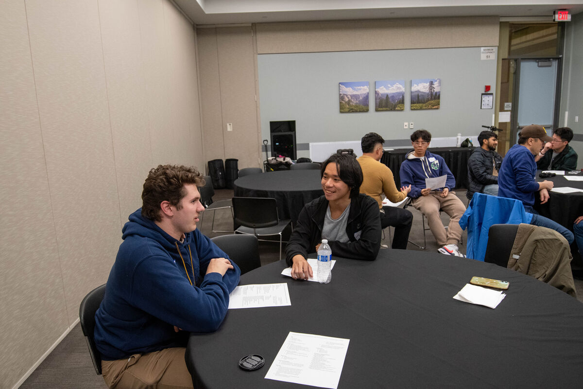 A mentor and a student talking across a table at an ISMP meeting