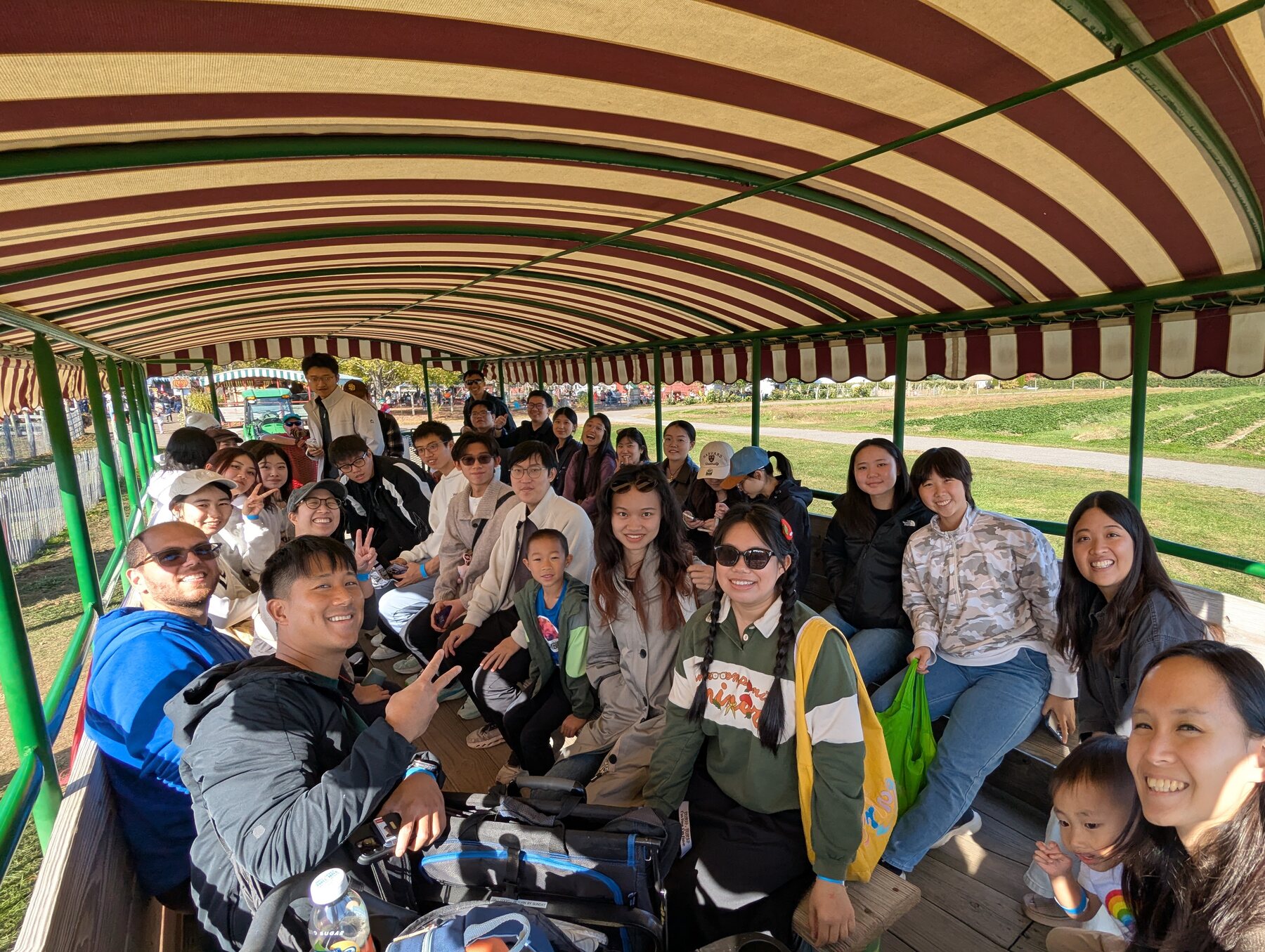 About twenty-five ISMP students, mentors and children on a hayride wagon at an apple orchard