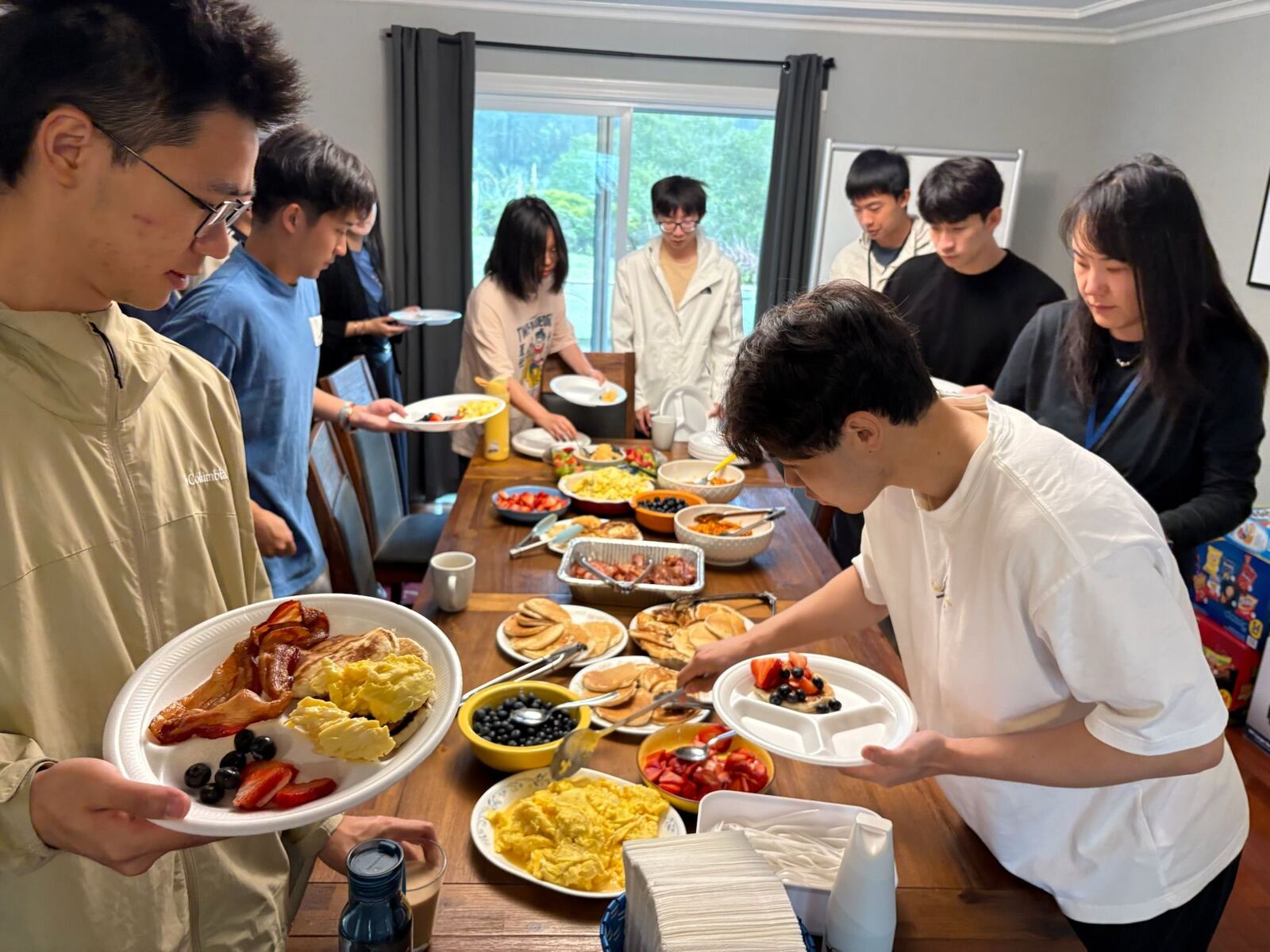 Students and mentors serving a shared meal together at an ISMP house